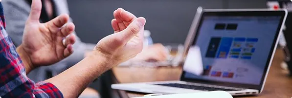 Time em reunião de alinhamento técnico ao lado de notebook aberto